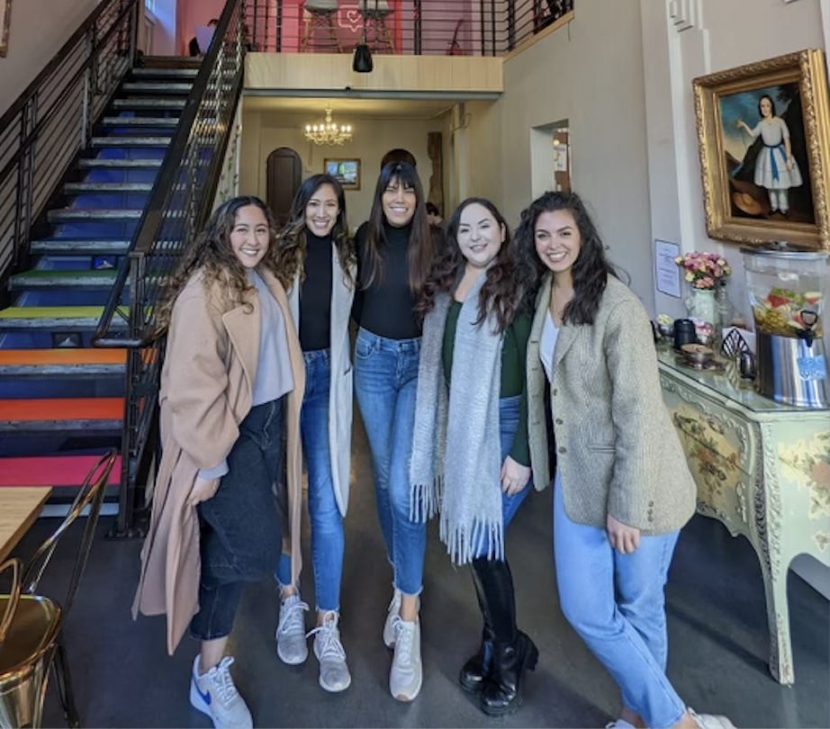 Five Latinas standing in a cafe
